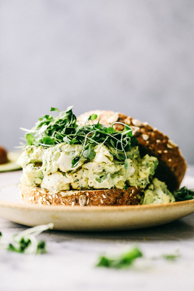 Avocado egg salad on a sandwich with Brussel sprouts. 