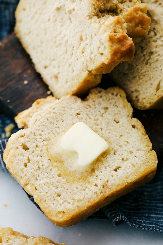 Warm buttery bread sliced up with a slice of butter on top that is slowly melting. . 