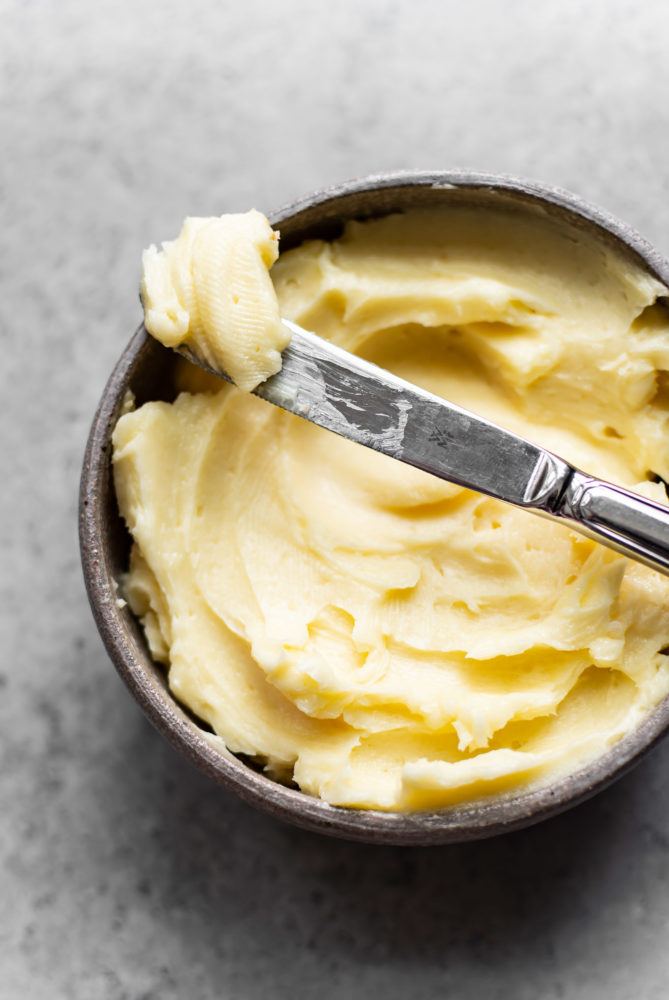 Honey butter in a bowl with a knife laying on top. 