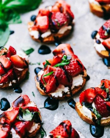 Strawberry bruschetta on a plate with balsamic dressing drizzled overtop.