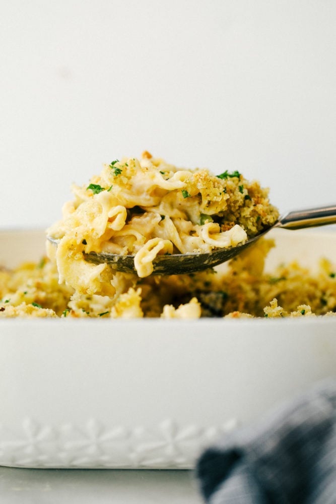 Tuna noodle casserole lifted up from the pan with a metal spoon. 