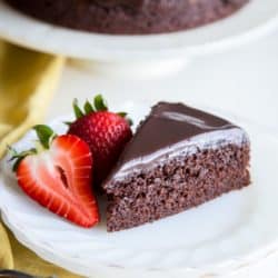 A slice of chocolate cake on a plate with strawberries