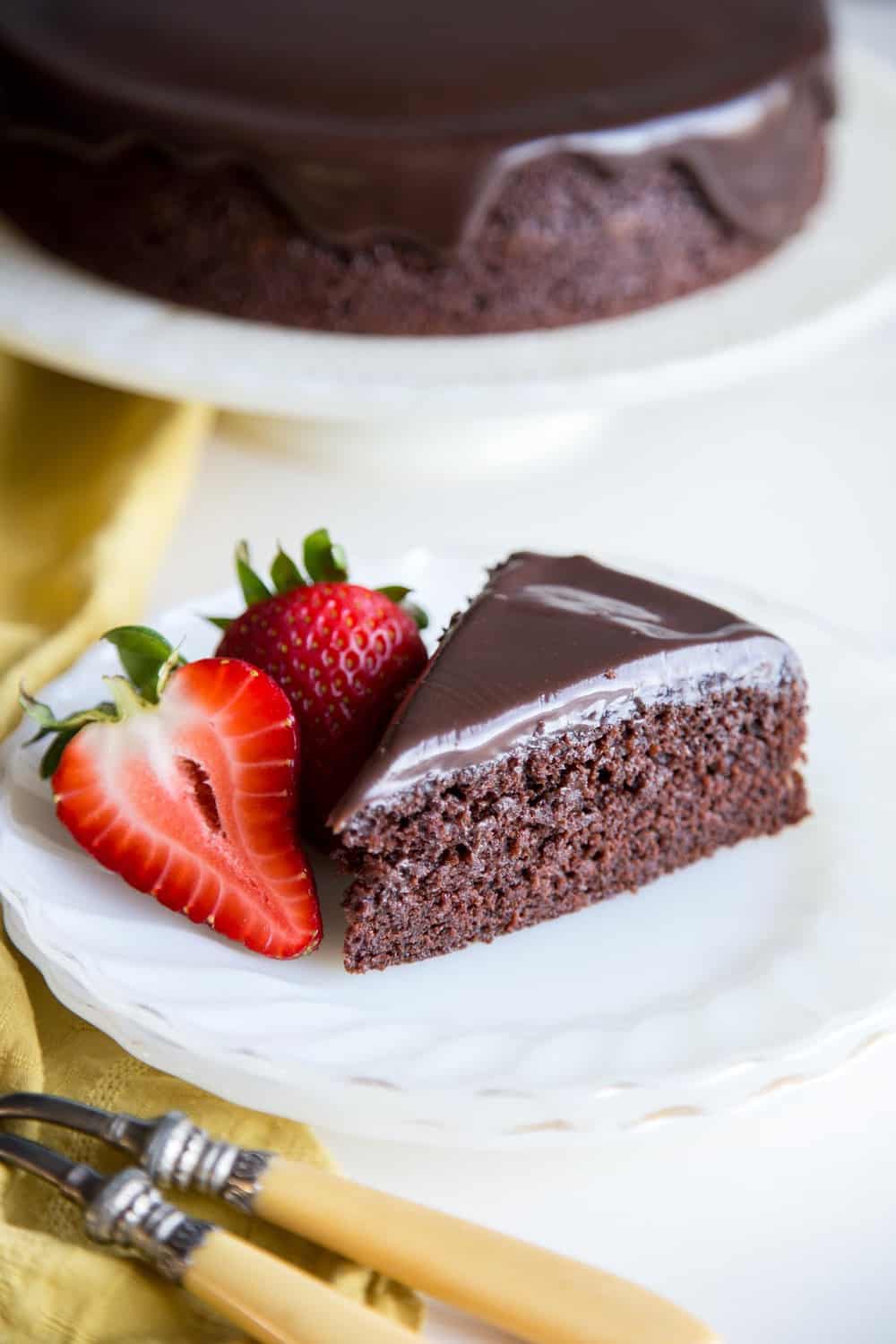 A slice of chocolate cake on a plate with strawberries