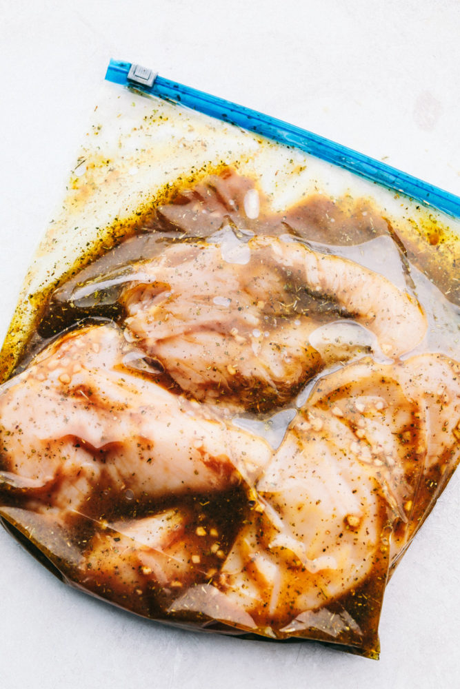 Chicken marinating in a ziploc bag.