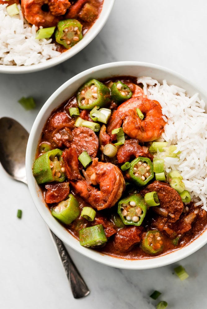 A bowl of New Orleans Gumbo and rice topped with scallions.