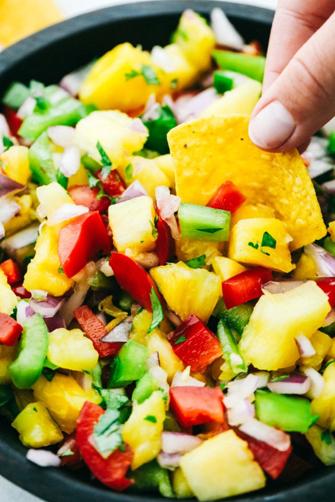 Dipping a chip into pineapple salsa.