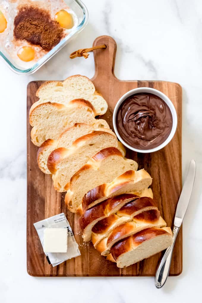 Una imagen de una hogaza de pan challah en rodajas con nutella.