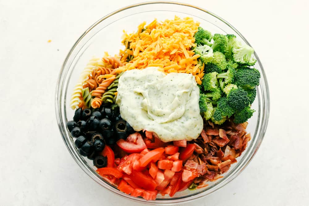 Bacon Ranch Pasta Salad ingredients in a clear bowl.