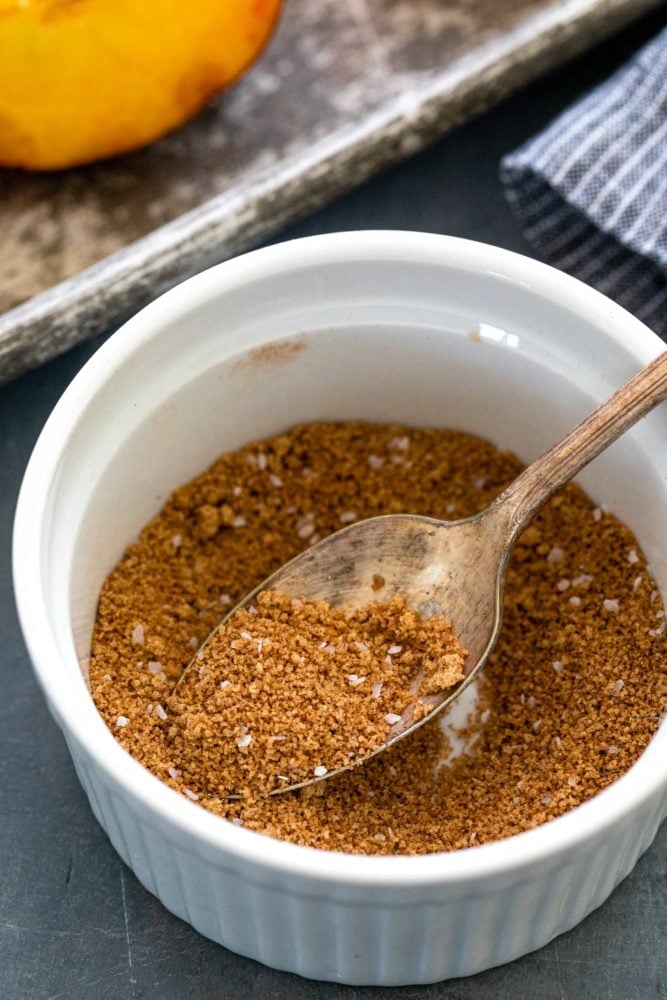 brown sugar and spices in a white ramekin with a silver spoon. 