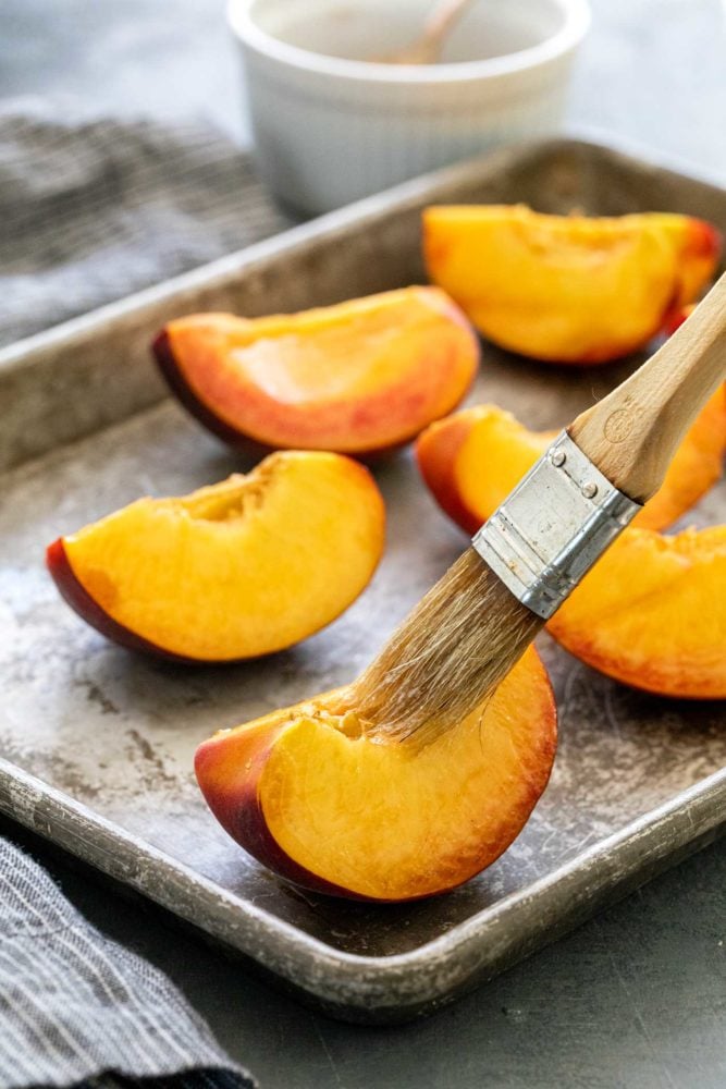 quartered peaches on a sheet tray