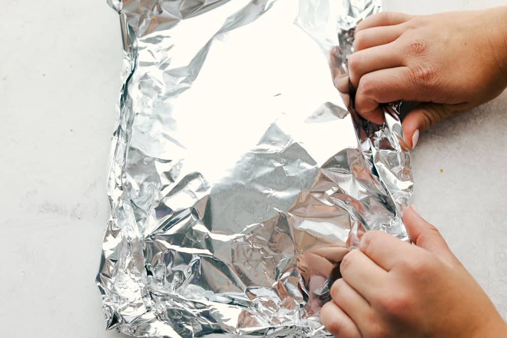 Foil packet rolled up with hands. 