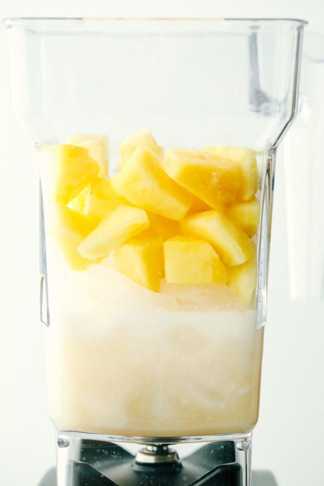 Pina Colada ingredients in a blender ready to be mixed.