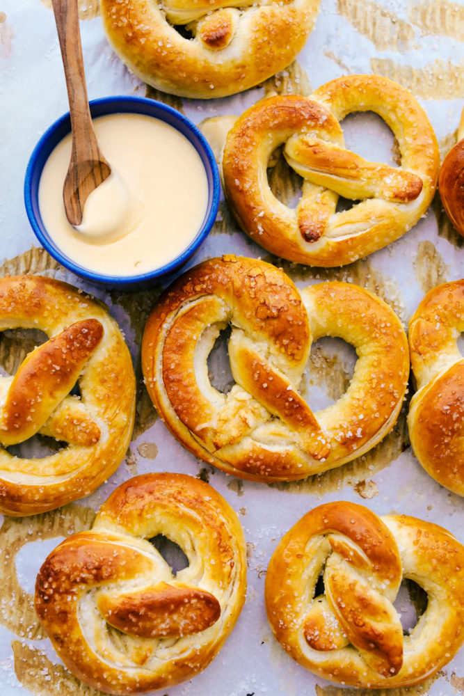 Finished soft pretzels with cheese dip in a blue bowl.
