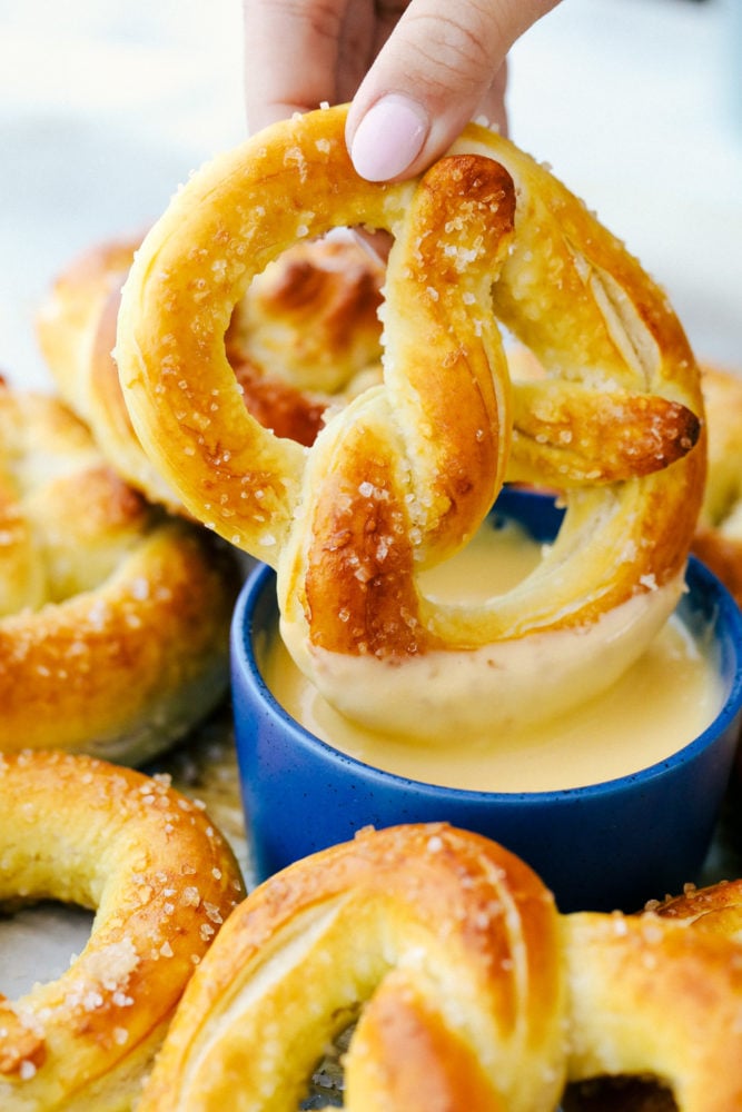 Dipping a pretzel in cheese sauce.