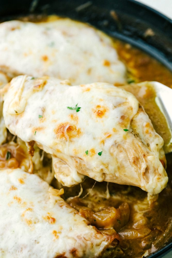 Close up on ooey gooey cheese from skillet french onion chicken.