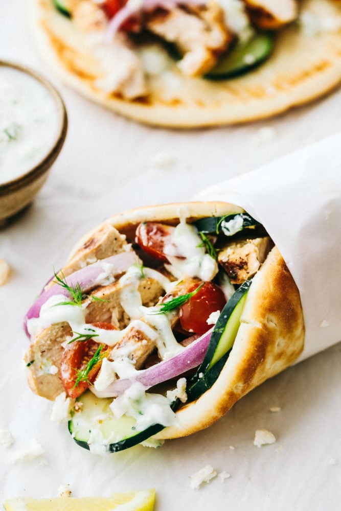 Homemade chicken gyro with tzatziki wrapped up in parchment paper. 