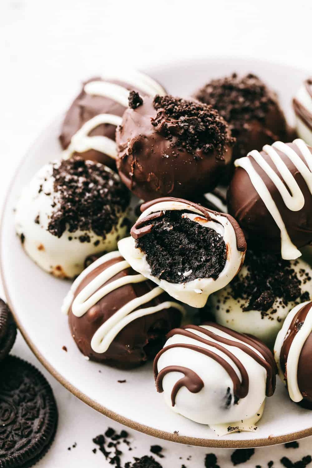 Oreo truffles stacked on a white plate.