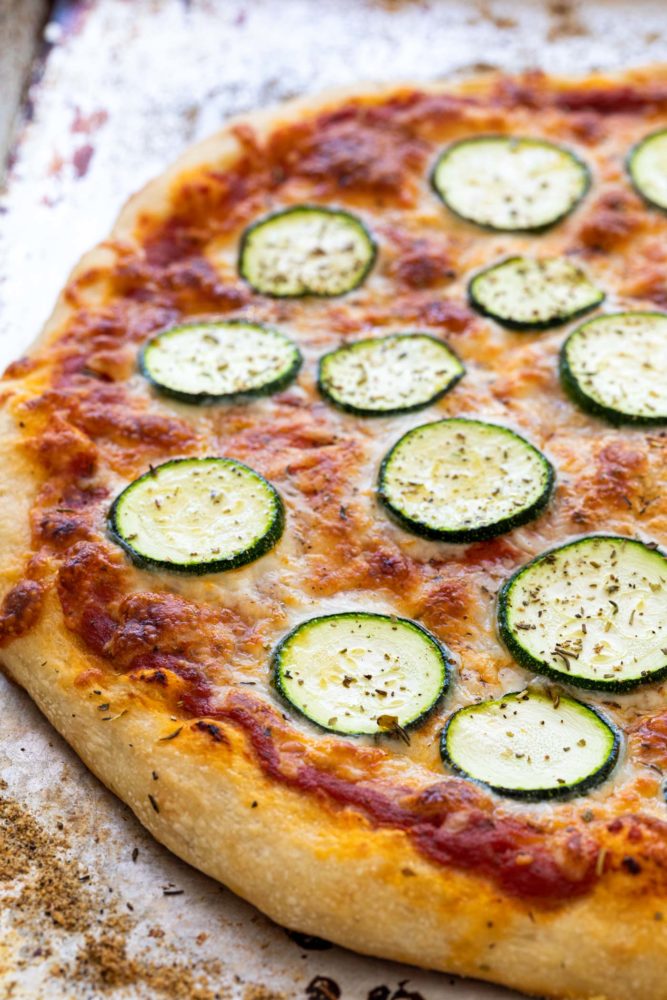 Oven baked pizza with slices of zucchini on top