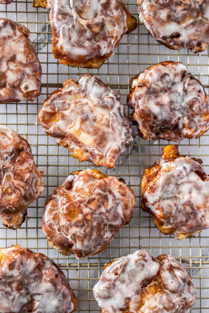 Top down view of apple fritters on a gold wire rack