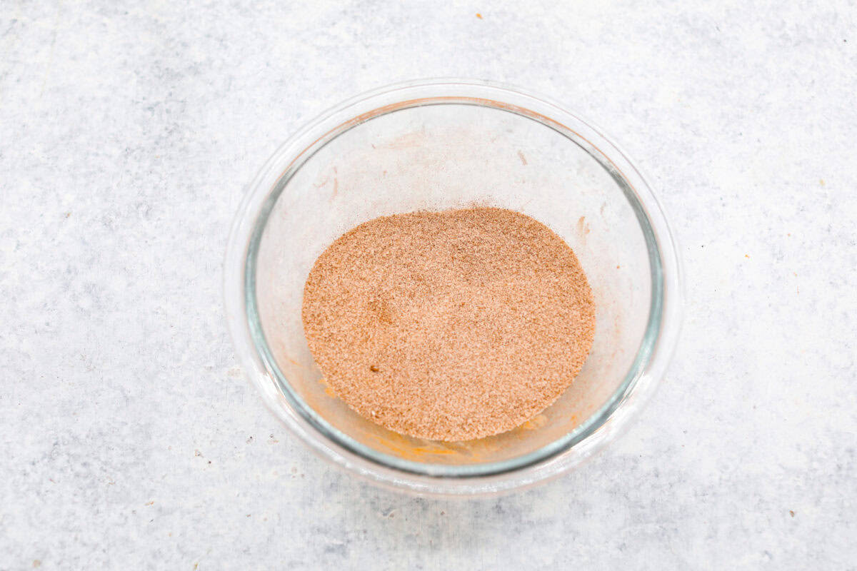 Overhead shot of cinnamon and sugar mixed in a bowl. 