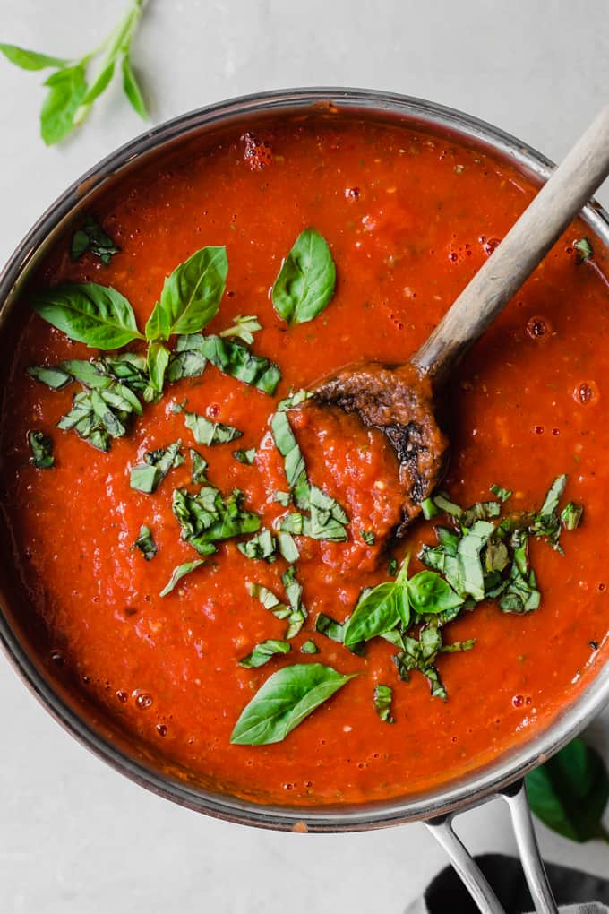 Tomato Sauce in a pan with wooden spoon. 