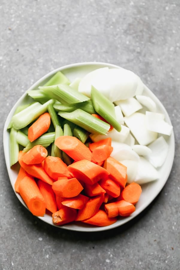 A plate full of cut up vegetables. 