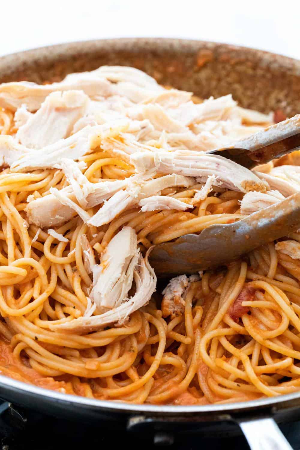 Shredded chicken on top of pasta