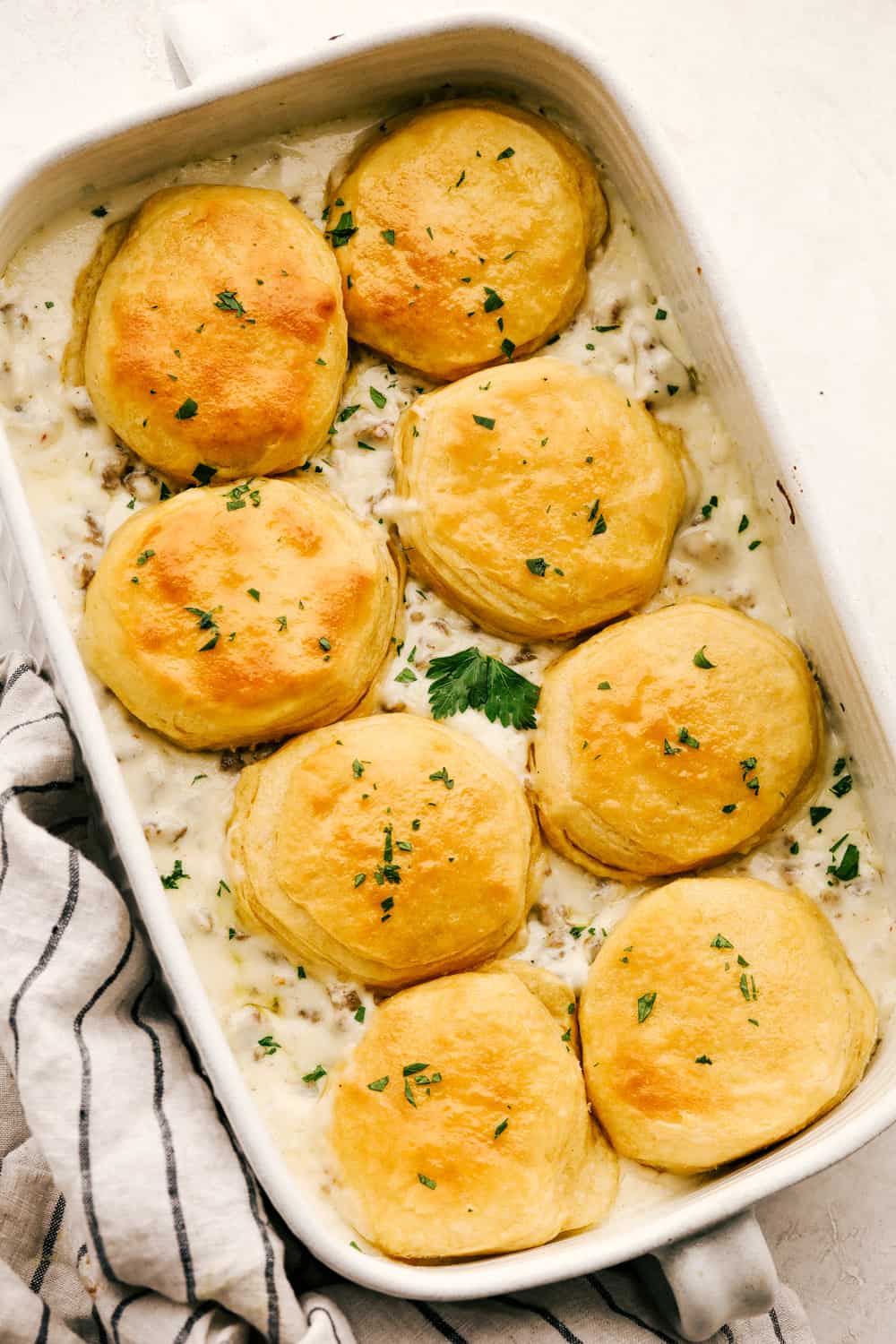 Golden flakey biscuits with savory rich sausage gravy in a pan.