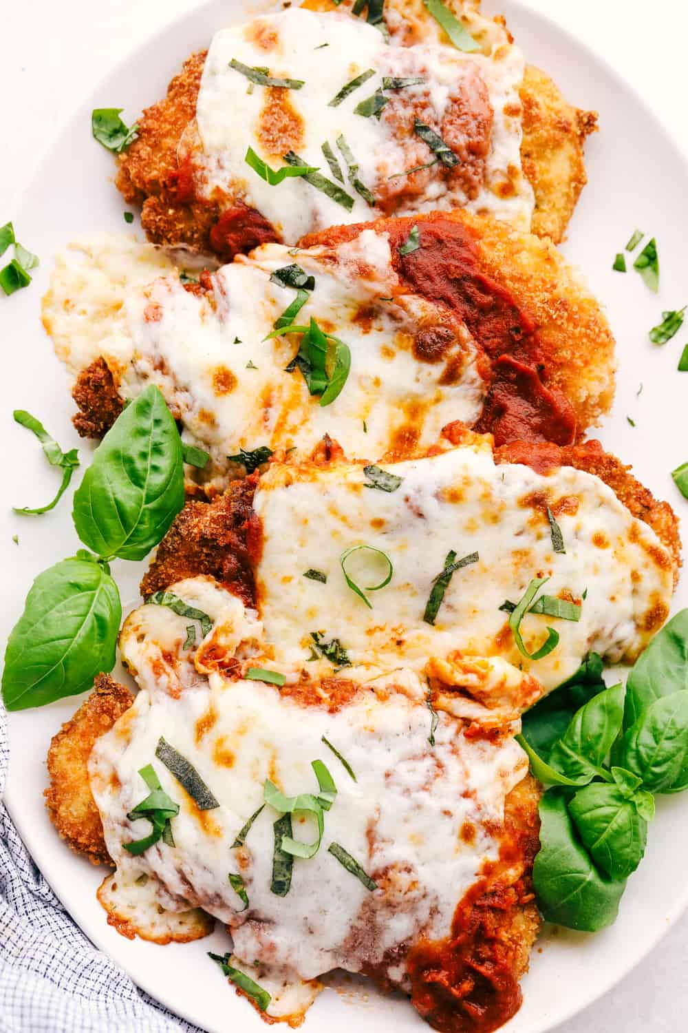 Parmesan Chicken on a plate with marinara and cheese. 