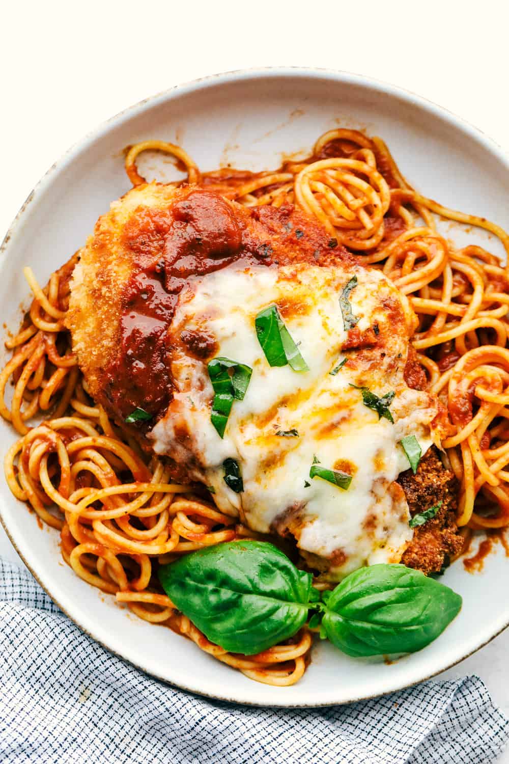 Parmesan chicken on a bed of spaghetti with marinara sauce. 