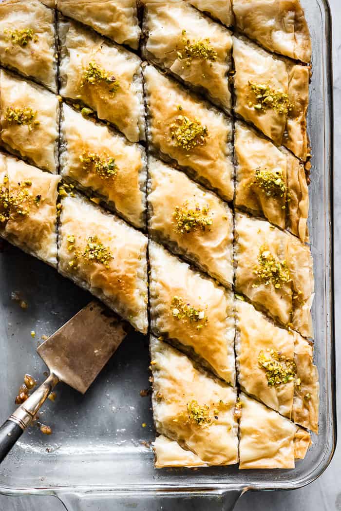 Baklava in a pan with a serving spoon.