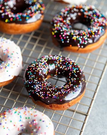 Glazed donuts with sprinkles on a wire rack