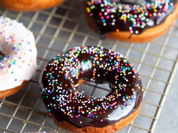 Glazed donuts with sprinkles on a wire rack
