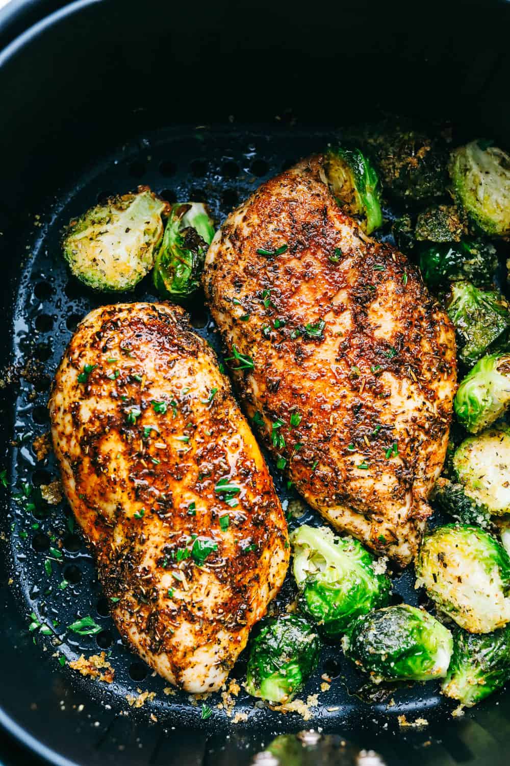 Overhead shot of tender and juicy air fryer chicken cooked in the air fryer basket. 