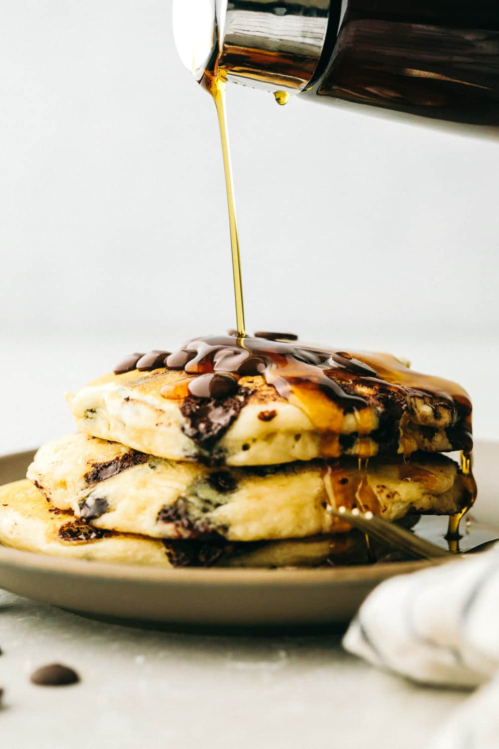 Verter el almíbar encima de los panckaes con chispas de chocolate.