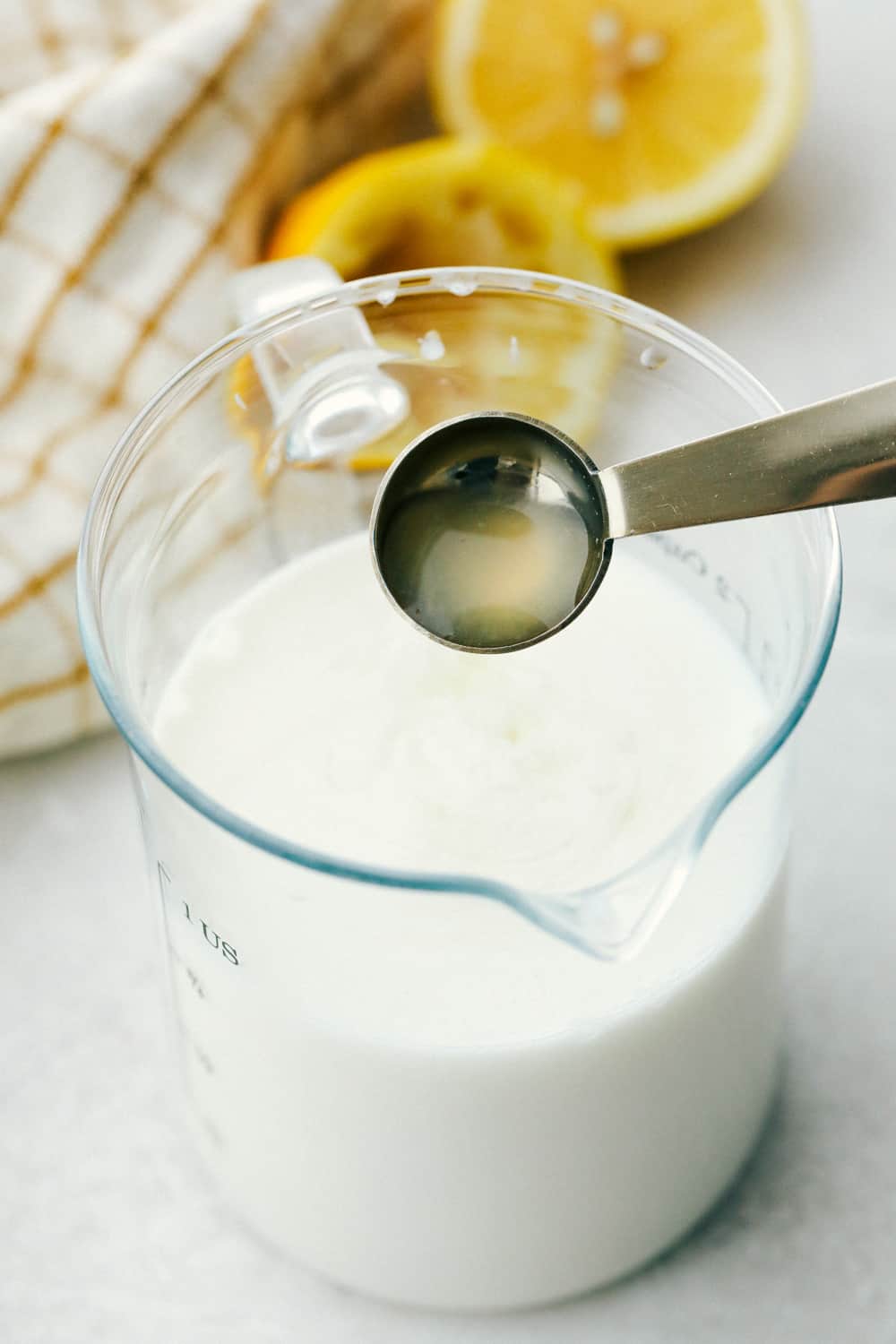 Lemon juice pouring into milk for homemade buttermilk. 