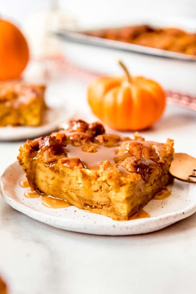 A slice of pumpkin bread pudding with caramel sauce.