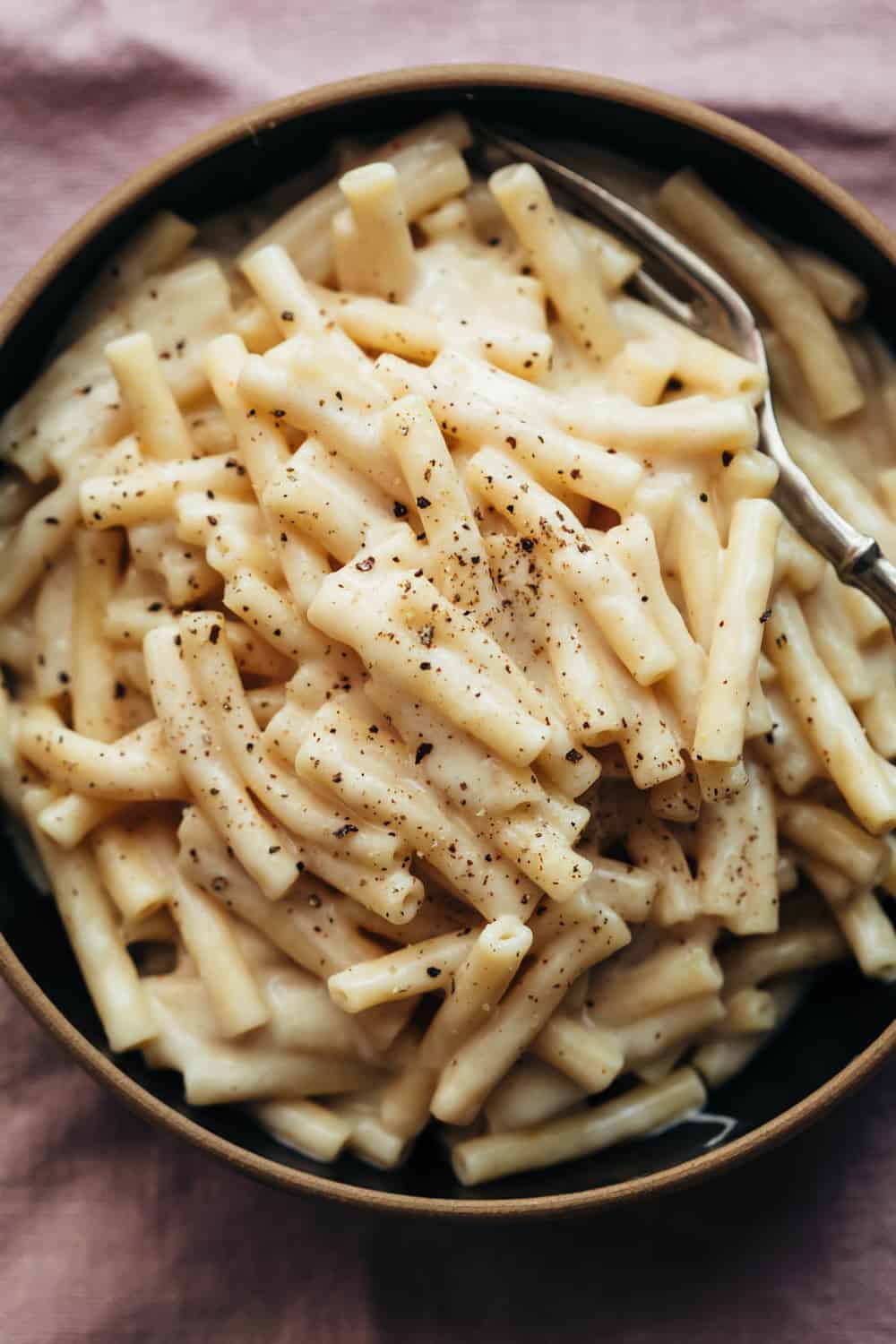 Macarrones con  queso instantáneos servidos en un tazón con un tenedor