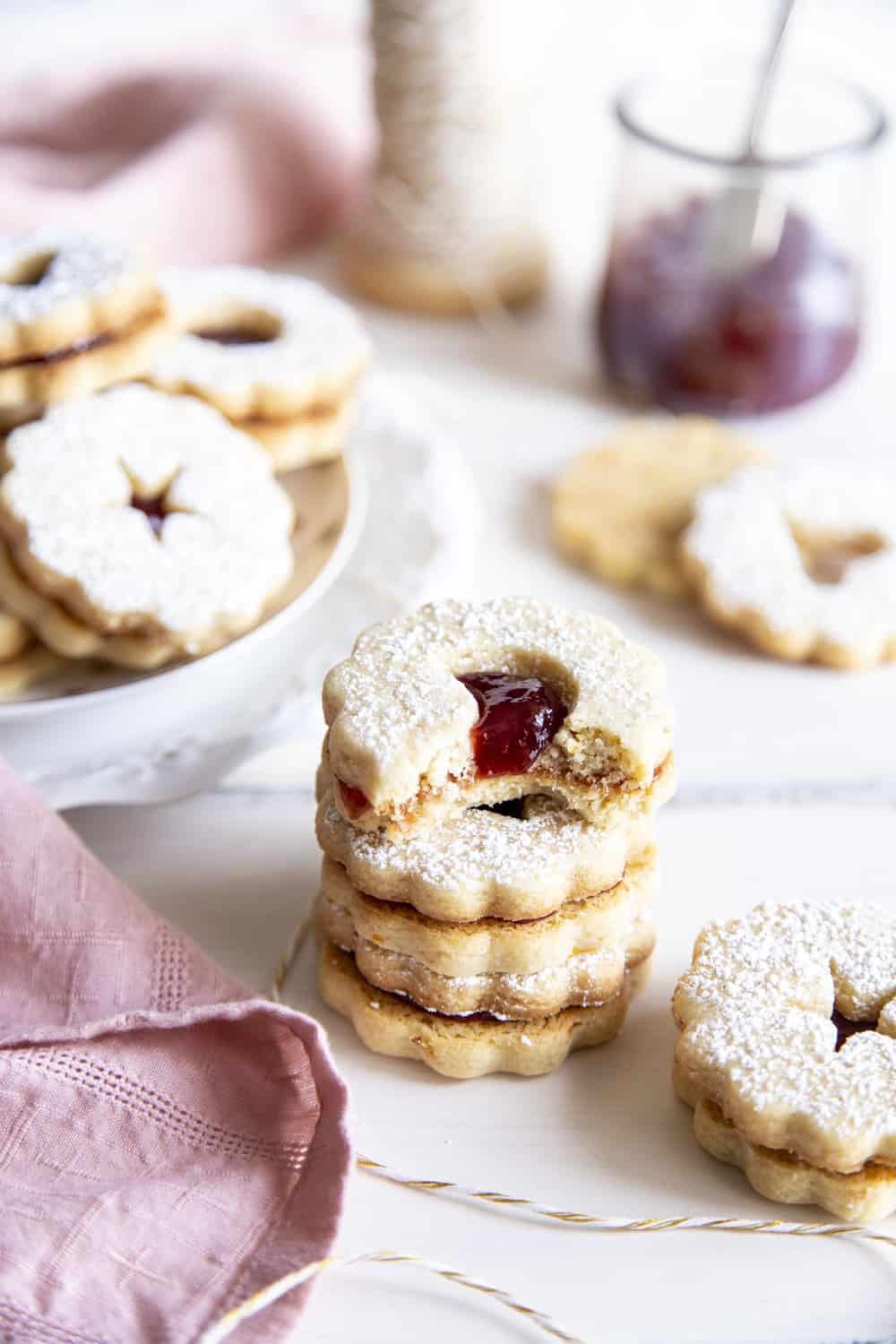 A stack of Linzer Cookies with a bite out of it. 