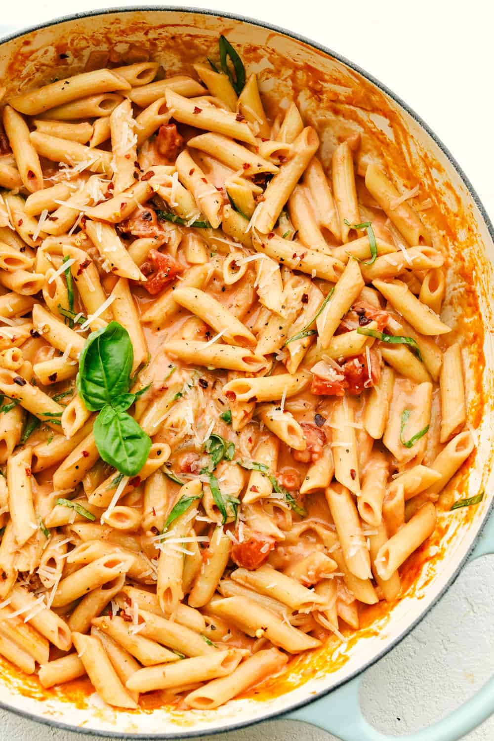 Creamy Penne Alla Vodka in a pot, with basil.