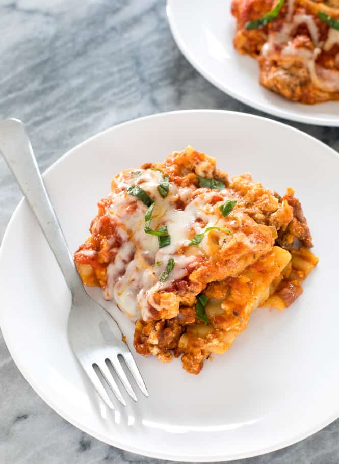 Slow cooker lasagna on a white plate with a fork on the side. 