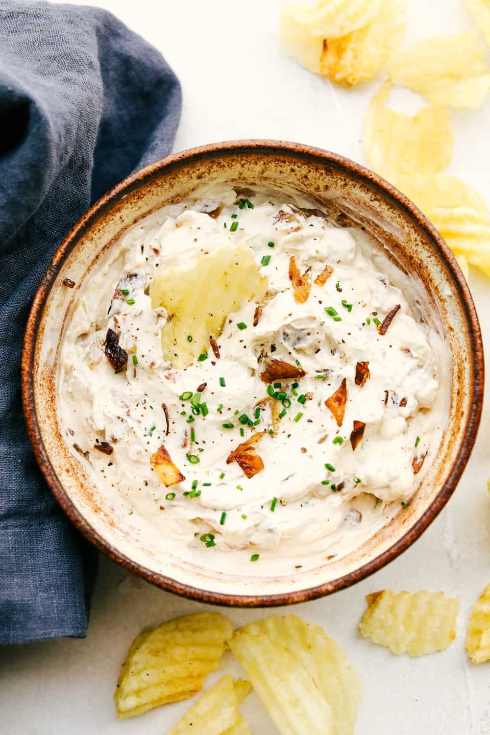 The Best French Onion Dip in a bowl with chips for dipping.