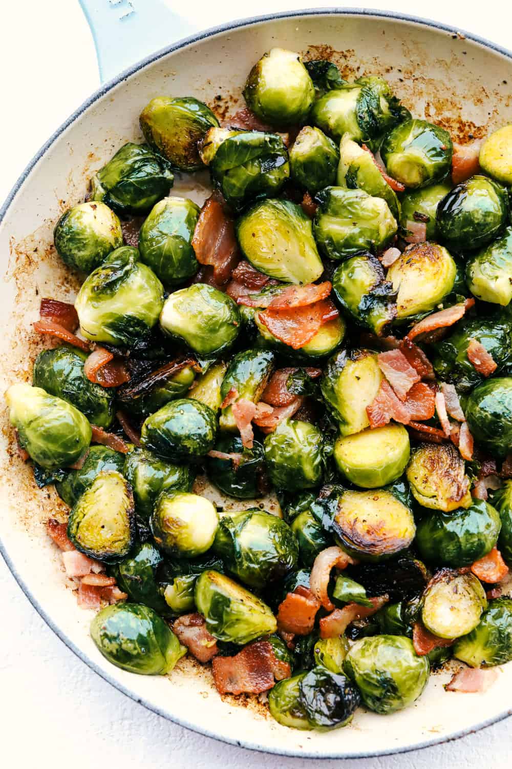 Brussel sprouts with bacon and maple syrup in a white bowl.