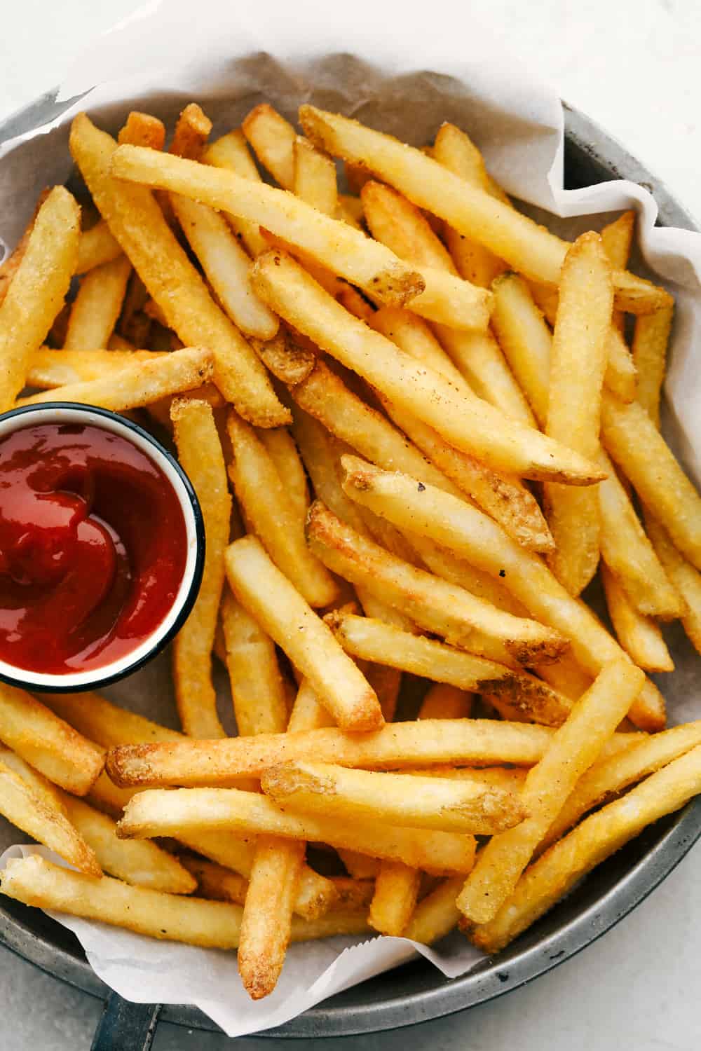 French fries on a plate with ketchup. 