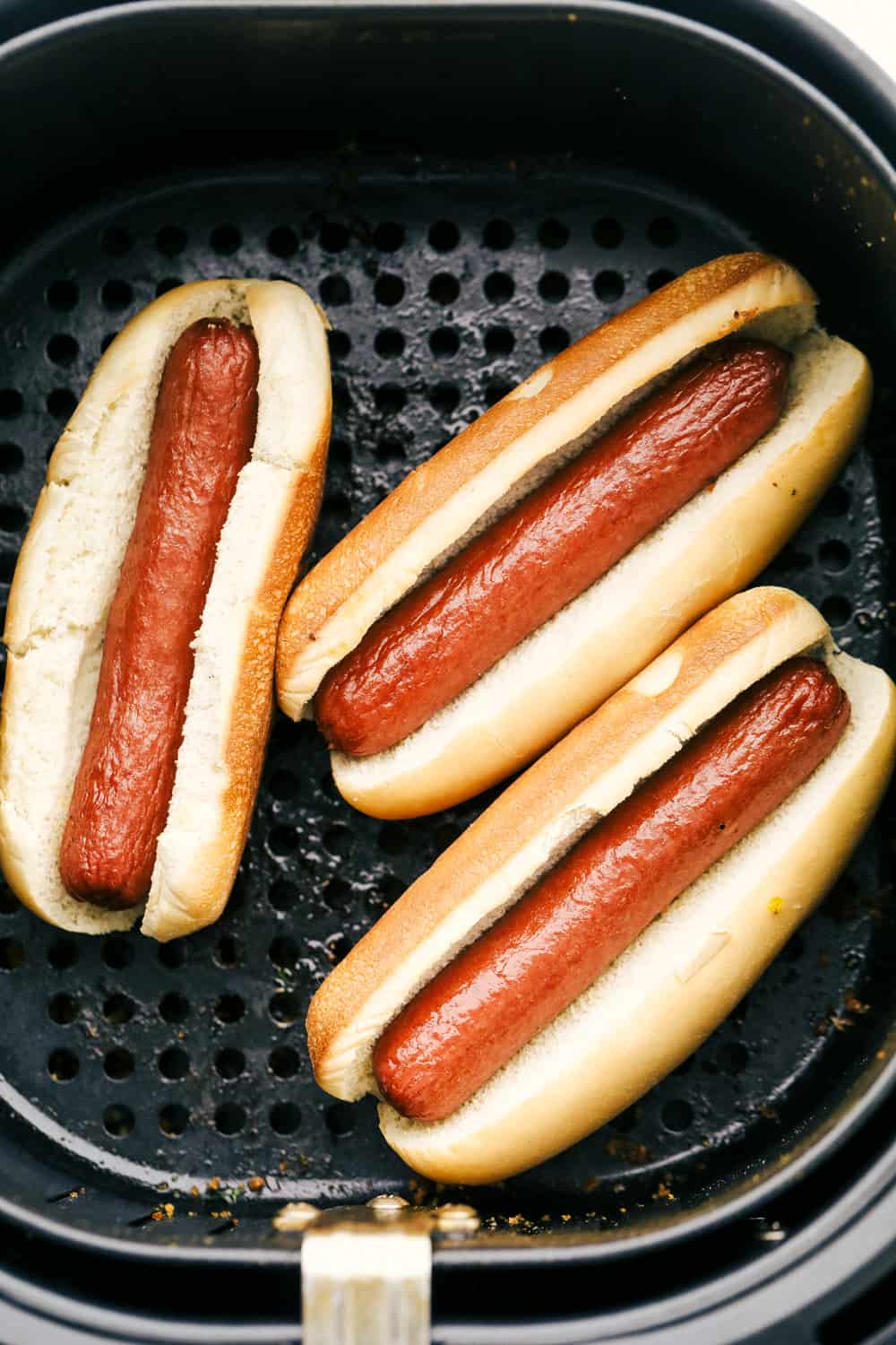 Hot dogs in buns in an air fryer. 