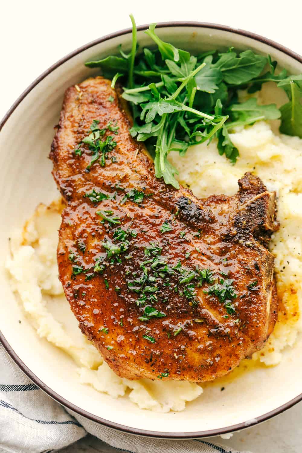 Juicy and tender air fryer Pork chops on a bed of mashed potatoes. 