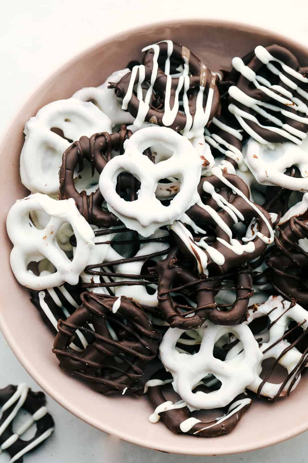 A bowl full of white and dark chocolate covered pretzels. 