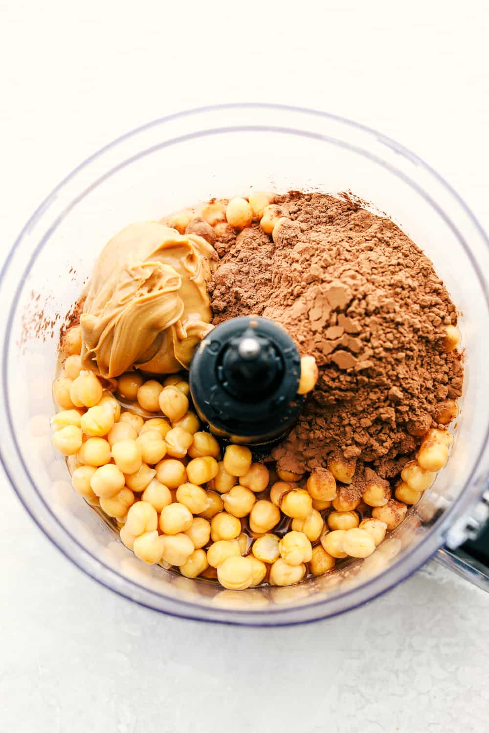 A food processor with the ingredients for chocolate hummus.