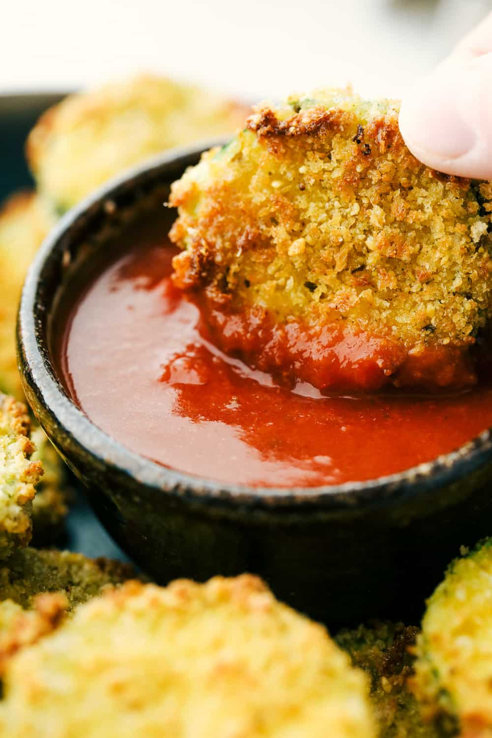 Dipping an air fried zucchini chip in ketchup. 