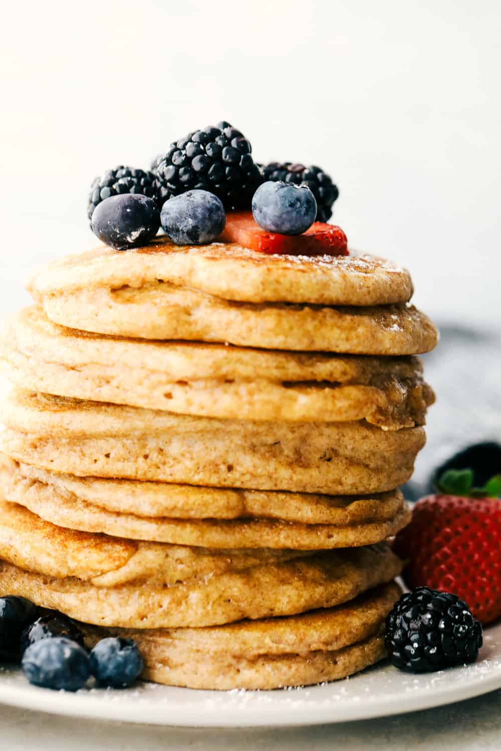 A stack of whole wheat pancakes with berries on top. 
